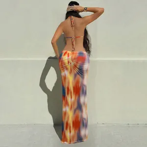 Detailed back view of a vibrant tie-dye halter neck backless maxi dress with tie strings