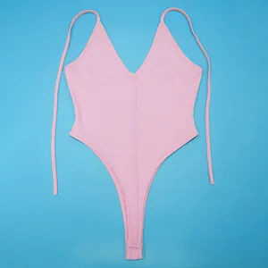 Professional flat lay detail view of a pink sexy high-cut bodysuit on vibrant blue background
