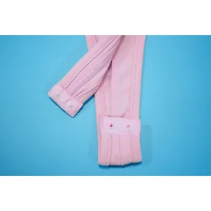 Macro detail view of pink bodysuit bottom closure with snap buttons on blue background