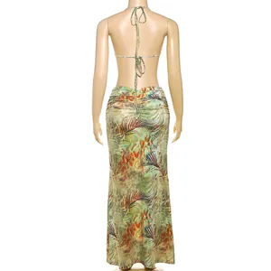 Back view of a halter neck backless maxi dress with vibrant tropical leaf print.