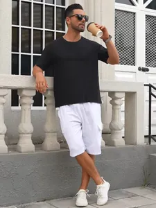Model wearing white linen cargo shorts with pockets and black t-shirt in outdoor setting