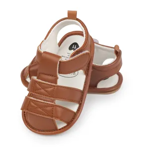 Detail view of brown faux leather baby sandals with adjustable velcro straps and soft sole.