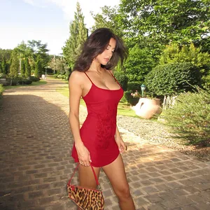 Elegante vestido rojo con pedrería, corte ajustado y escote en U en un jardín exterior