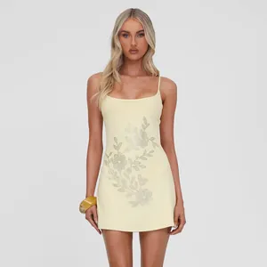 Elegante mini vestido ajustado amarillo pálido con pedrería floral y cuello en U.