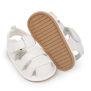 Close-up detail of white baby sandals with soft brown non-slip rubber sole for toddlers