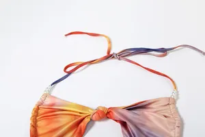 Close-up detail of sunset gradient halter neck dress with elegant pearl chain accents