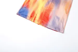 Close-up of vibrant multi-colored tie-dye fabric and neat hem stitching on slim dress