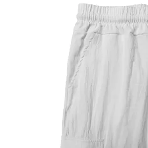 Detail shot of white linen cargo shorts showing elastic waist and pocket texture