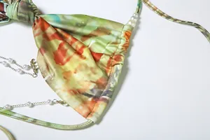 Close-up of sexy halter neck dress with pearl chain detail and abstract print pattern
