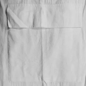 Close-up macro view showing texture of white linen fabric and pocket detail on cargo shorts