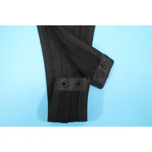 Close-up macro detail of the black fabric and snap button closure on women bodysuit garment