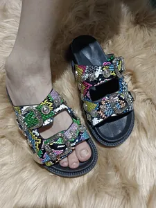 Detail of colorful snakeskin platform sandals with metal rivets and buckles.