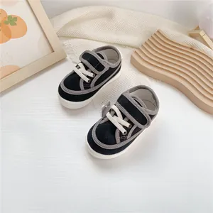 Detail shot of navy blue toddler canvas shoes with soft soles and adjustable velcro straps