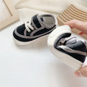 Close-up showing the flexible soft sole of these black and grey children's canvas sneakers