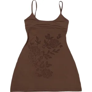 Detalle de un vestido de tirantes marrón ajustado con motivos florales de strass.