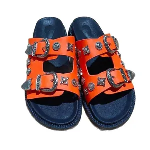 Vibrant orange platform slides with ornate silver metal buckles and decorative studs