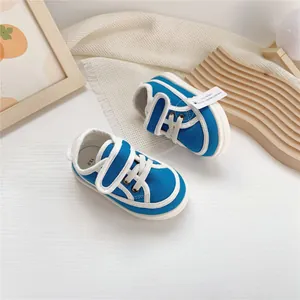 Detailed top view of blue and white baby canvas shoes with velcro strap closure