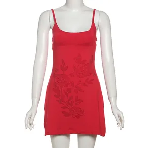 Primer plano de un vestido ajustado rojo con tirantes y elegantes motivos florales de pedrería