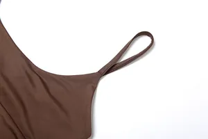 Primer plano del tirante fino y la textura suave de la tela marrón de un vestido lencero