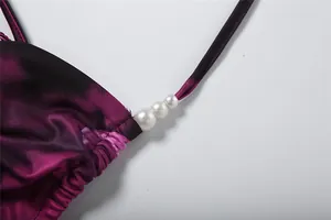 Detail showing three white pearl beads and gradient purple fabric of the sexy halter dress.