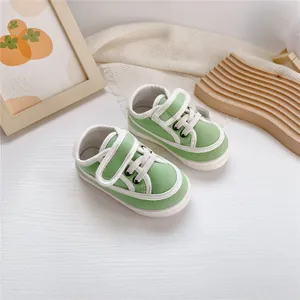 Green soft-sole canvas shoes for toddlers with adjustable velcro and white laces