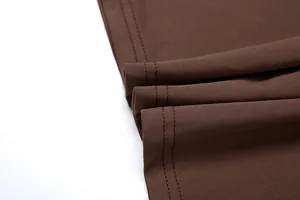 Primer plano del dobladillo con doble puntada y textura fina de la tela marrón