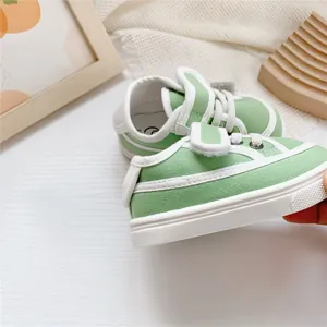 Close-up detail showing the soft sole and velcro strap of green children's canvas sneakers