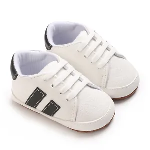 Close-up of white baby pre-walker sneakers with soft soles and black accents.
