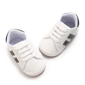 Detailed view of white baby walking shoes with soft soles and black side accents