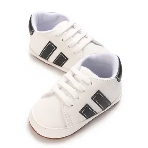 Classic white baby walking shoes with soft soles and black side stripe detail