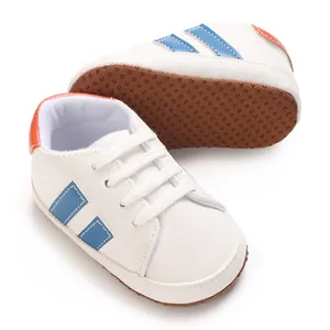 Close-up of white baby walking shoes with blue stripes and non-slip soft rubber sole