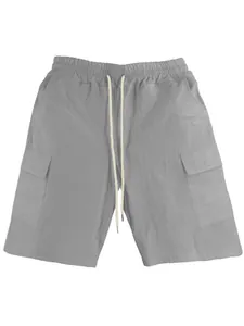 Close-up of grey cargo shorts with elastic drawstring waist and side flap pockets
