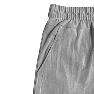 Detailed macro view of grey linen cargo shorts highlighting elastic waistband and side pocket