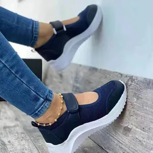 Detail of navy blue mesh Mary Jane sneakers with velcro strap and thick white sole.
