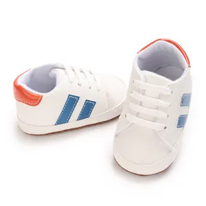 Macro view of white baby walking shoes with blue stripes and soft anti-slip soles