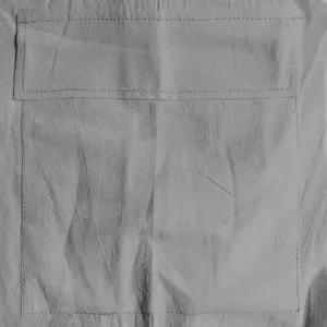 Close-up macro detail of a functional cargo pocket on grey linen casual mens shorts