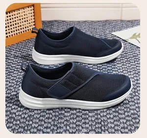 Close-up of navy blue mesh sneakers with lightweight white soles on a textured carpet