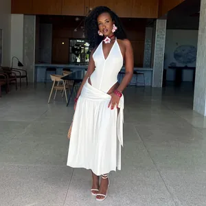 Elegant white two-piece set featuring halter top and high slit maxi skirt on model