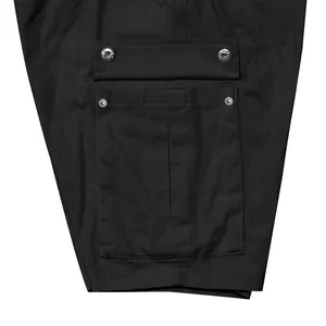 Macro view of pocket detail on black linen tactical cargo shorts with metal rivets