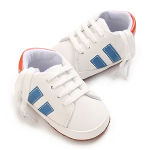 Detaillierte Nahaufnahme von weißen Baby-Sportschuhen mit blauen Streifen und weichen Sohlen