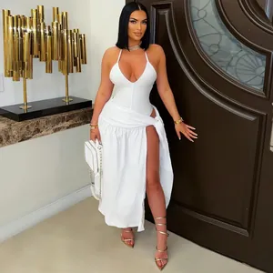 Fashion model wearing a white halter top and high slit skirt set in a luxury room