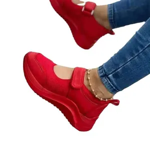 Red wedge Mary Jane sneakers with hook-and-loop strap and platform sole for women.