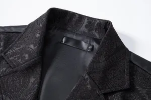 Detailed macro view of black paisley jacquard fabric on a men's slim fit suit vest collar