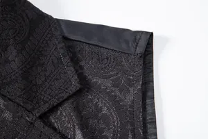 Macro detail showing the intricate black paisley pattern on a men's suit vest lapel