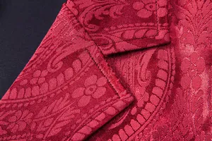 Detailed macro view of red paisley floral jacquard fabric on a men's suit vest lapel