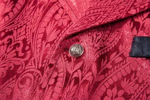 Close-up of red paisley jacquard fabric and vintage button on a men's vest