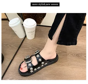 Primer plano de sandalias negras con plataforma, remaches de metal y hebillas
