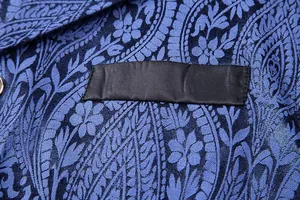 Macro detail of the intricate blue paisley jacquard fabric on a men's formal vest