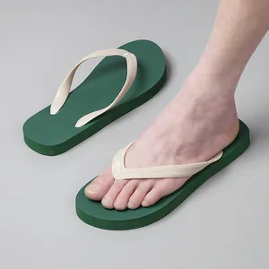 Dettaglio di infradito da uomo verde scuro e beige che mostrano la calzata comoda sul piede.
