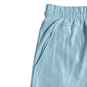 Detailed close-up view of the elastic waistband and side pocket of blue linen shorts